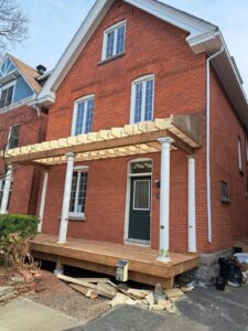 Front veranda rebuild on a red brick century home in Ottawa