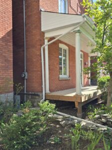 Front veranda rebuild on a red brick century home in Ottawa