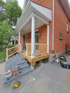 Front veranda rebuild on a red brick century home in Ottawa