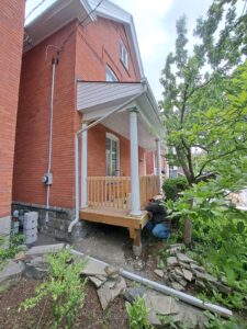 Front veranda rebuild on a red brick century home in Ottawa