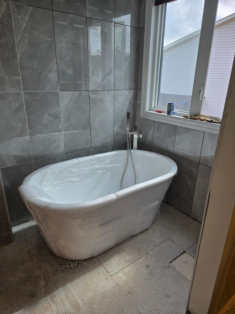 Freestanding soaker tub being installed in an Ottawa ensuite renovation