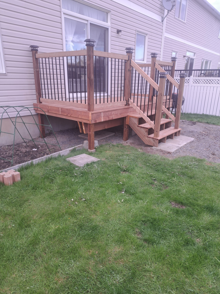 Finished stained wood deck with black metal railings, Ottawa